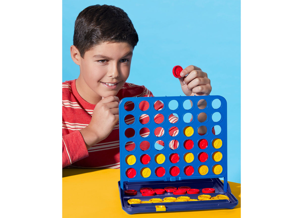 Hasbro Gaming Connect 4 board game with blue grid, red and yellow pieces, played by young boy