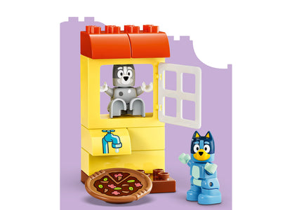 LEGO Bluey Pizza Girls building set with yellow house, red roof, Muffin minifigure, Bluey character, and pizza accessory