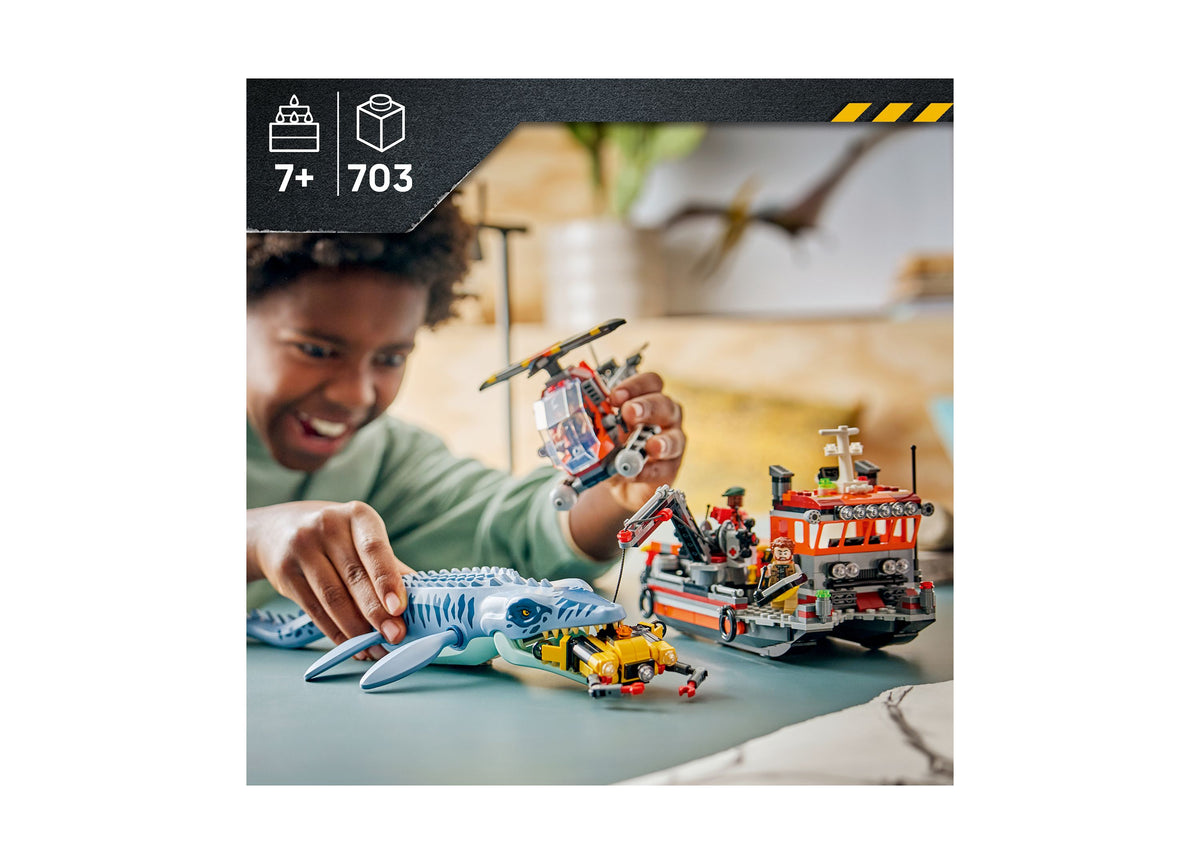 Child playing with LEGO Jurassic World Mosasaurus set featuring blue dinosaur, red boat, and yellow vehicle
