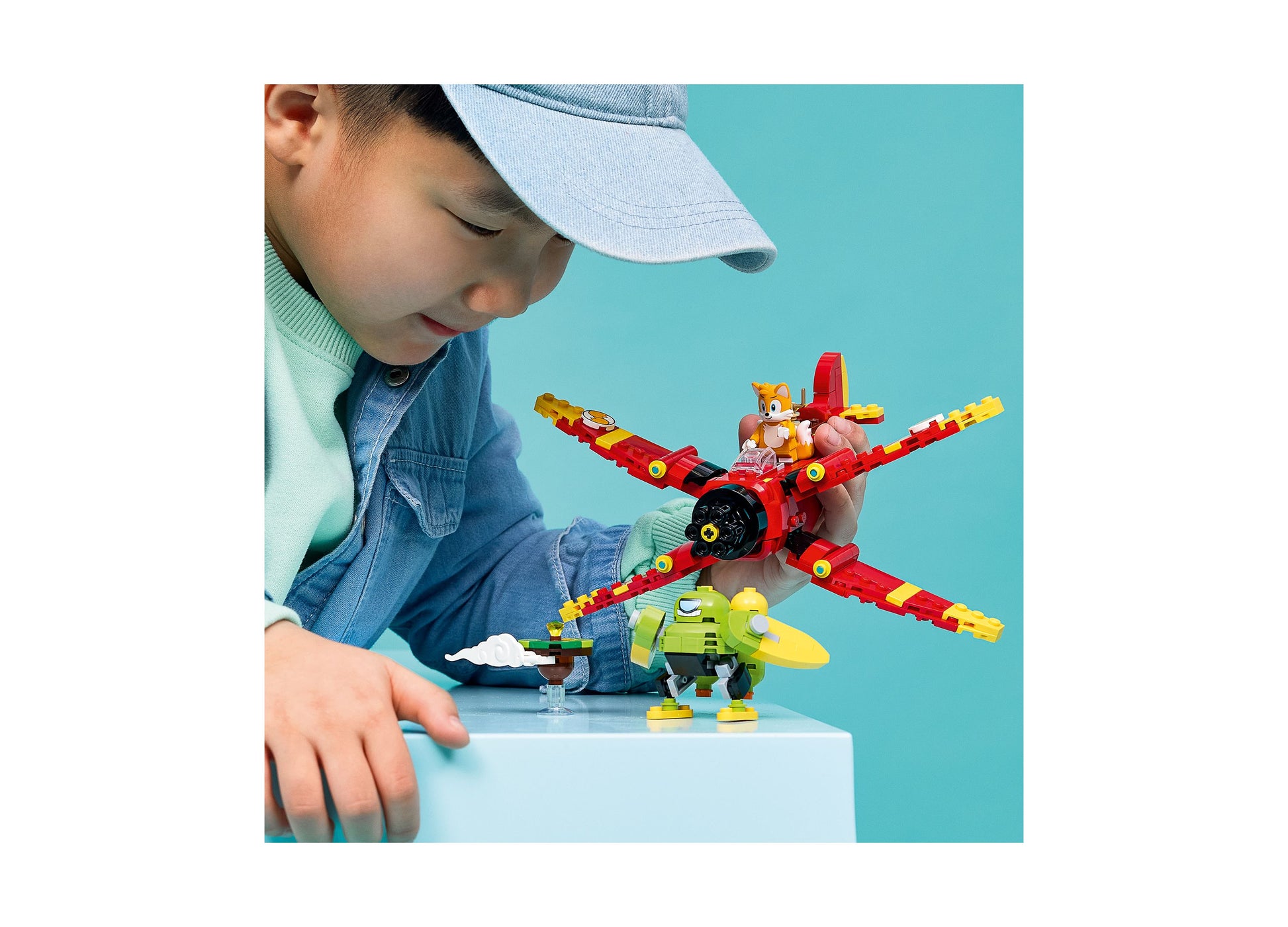 Child playing with LEGO Sonic Tails' Tornado-1 red and yellow aircraft building set