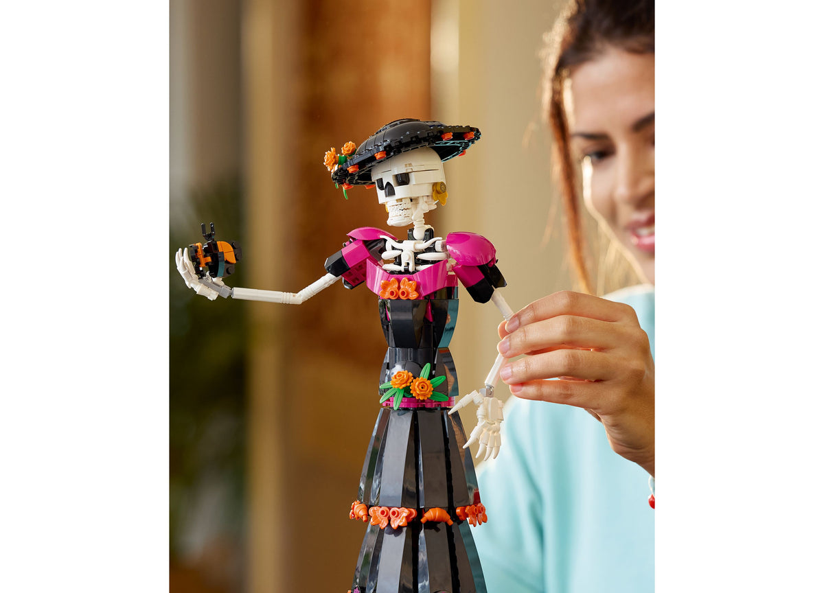 LEGO Ideas Day of the Dead La Catrina skeleton figure with poseable arms, wearing pink shoulder pieces and black skir...