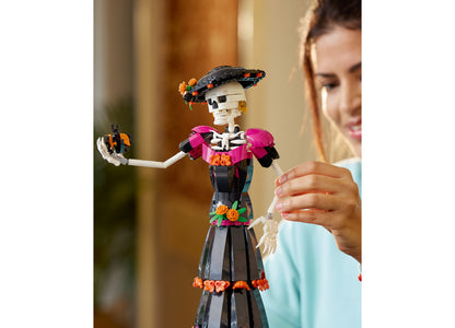 LEGO Ideas Day of the Dead La Catrina skeleton figure with poseable arms, wearing pink shoulder pieces and black skir...