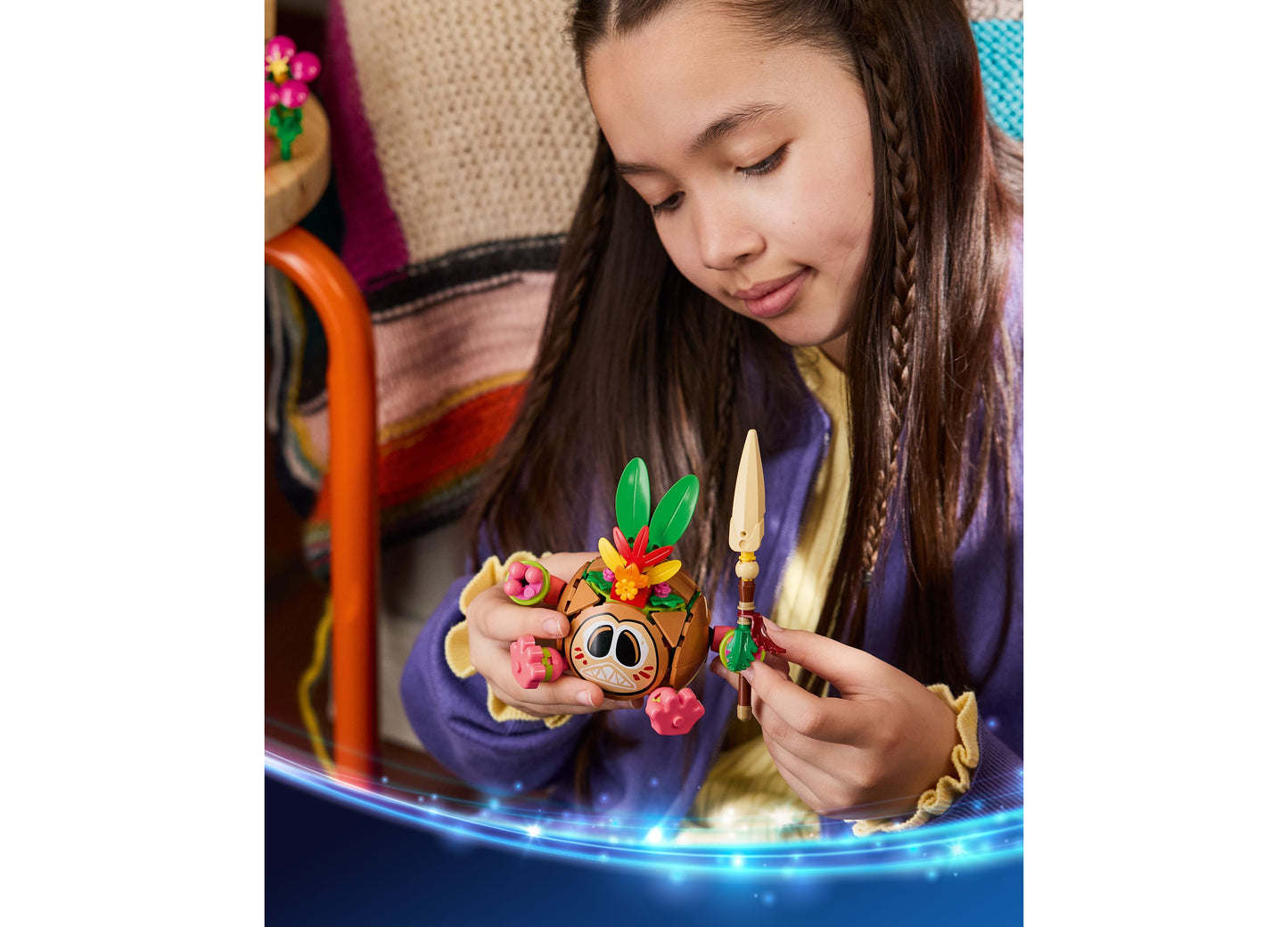 Girl holding LEGO Disney Moana Kakamora building set with colorful flowers and posable figure