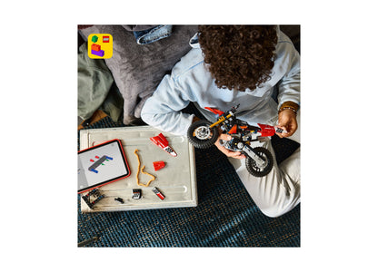 LEGO Ducati Desmo450 MX motorcycle building set with red and white pieces being assembled by child