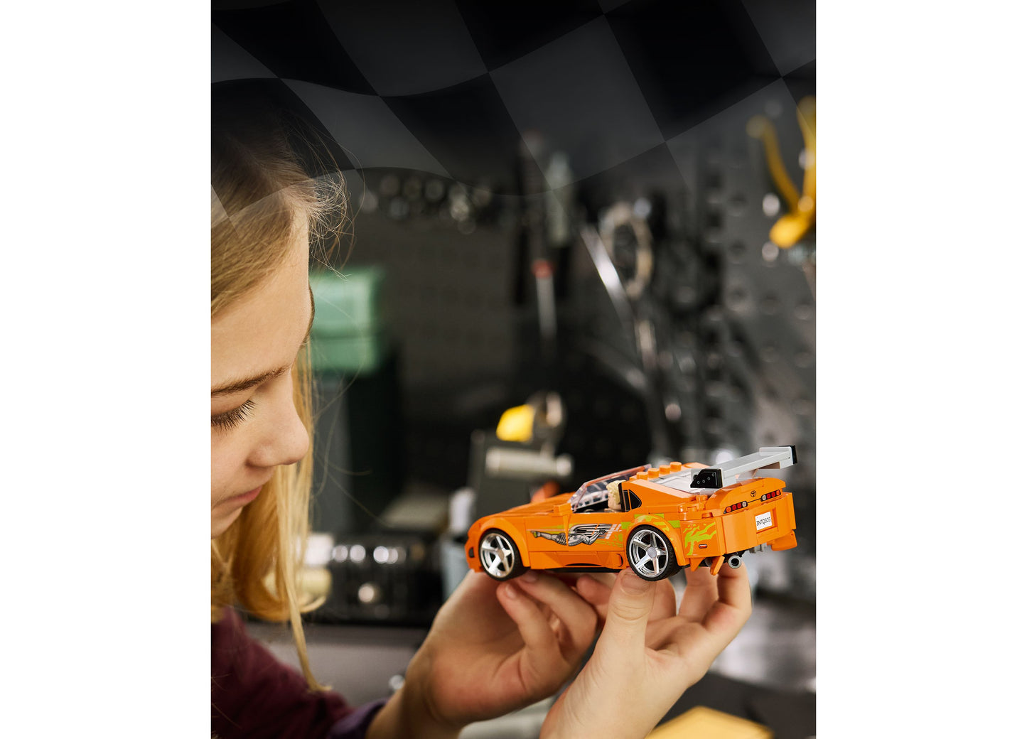 Girl holding orange LEGO Fast and Furious Toyota Supra MK4 building set model