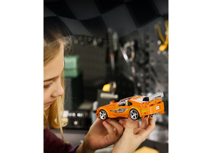 Girl holding orange LEGO Fast and Furious Toyota Supra MK4 building set model