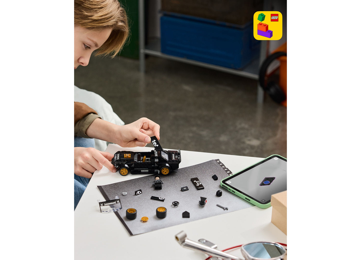 Child assembling LEGO Ken Block's '65 Ford Mustang Hoonicorn V1 building set with black and gold pieces