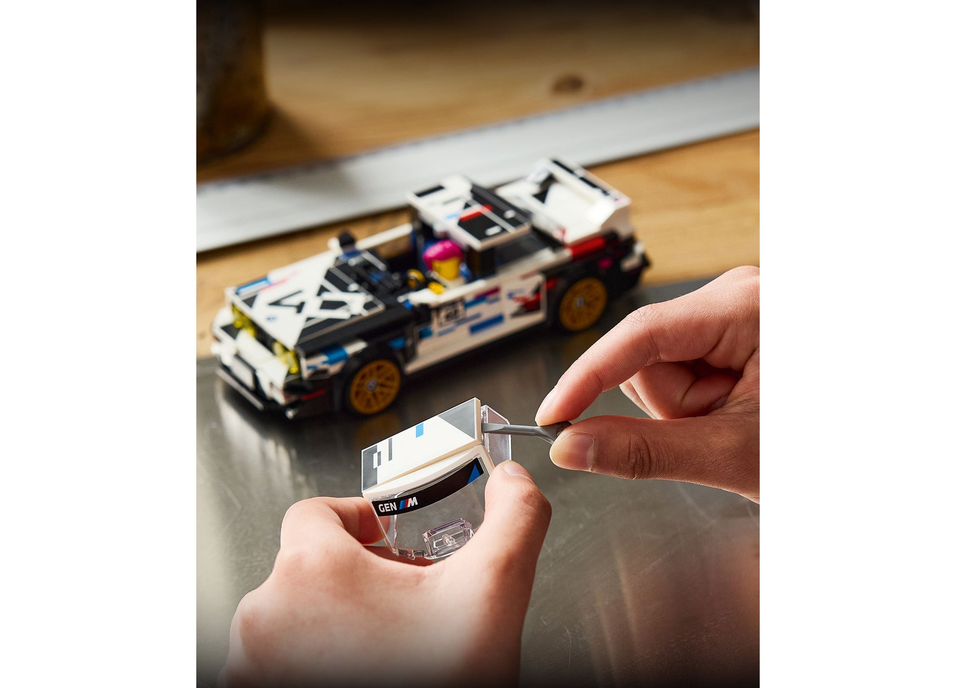 LEGO BMW M3 E30 77263 white and black racing car set held in child's hands