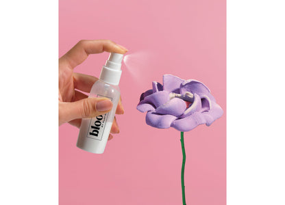 Play-Doh Blooms DIY Garden Bouquet Kit with purple flower and spray bottle on pink background