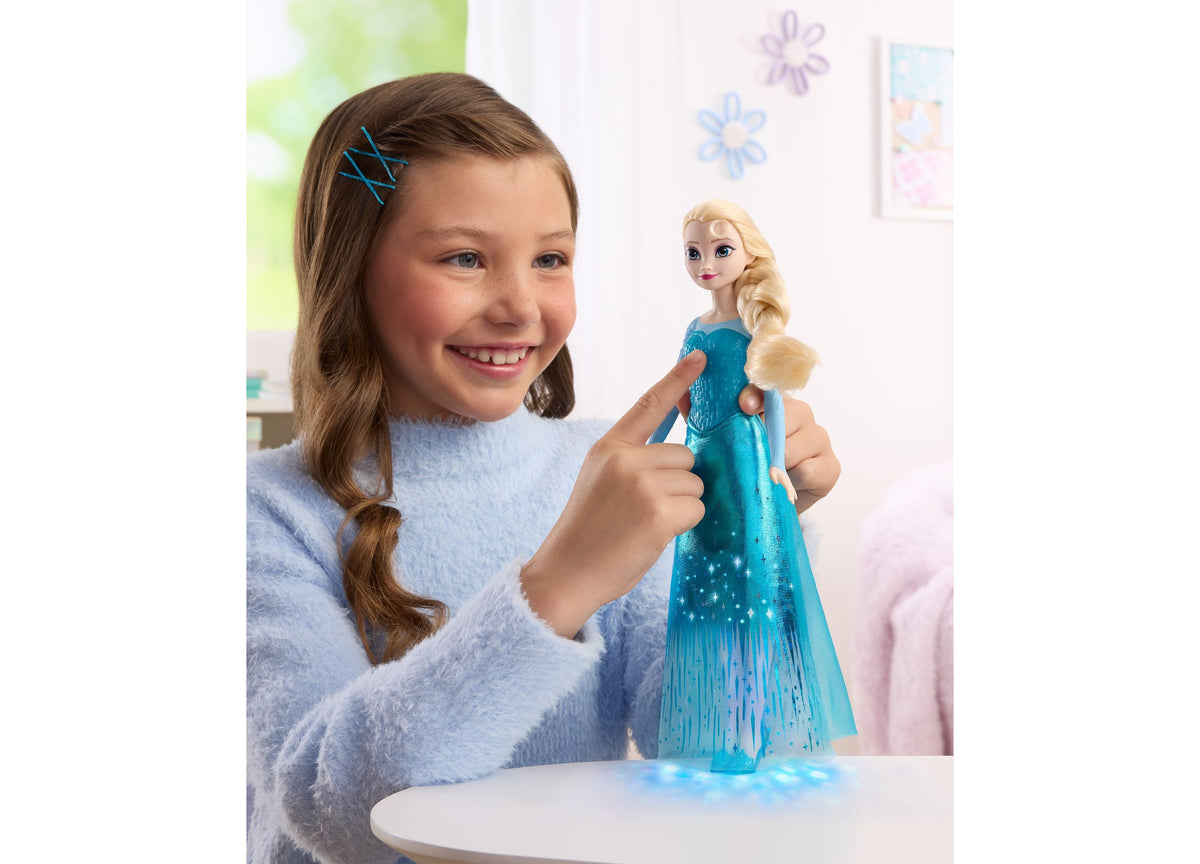Girl holding Disney Princess Singing Elsa 11" Light-Up Fashion Doll in blue dress with blonde hair