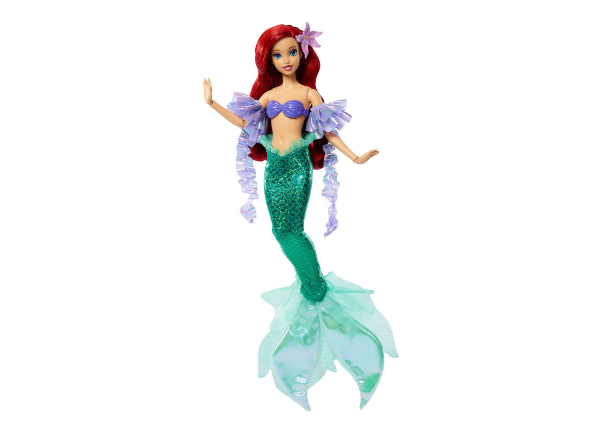 Disney Princess Ariel doll with red hair, purple flower clip, blue top, green sequined tail, and purple ruffled sleeves