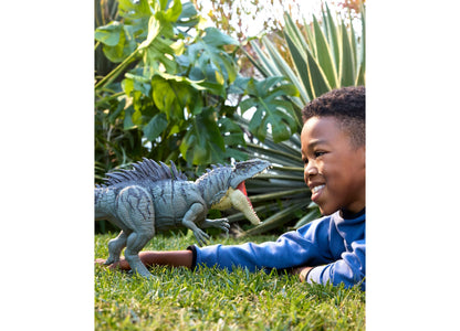 Blue Jurassic World Giganotosaurus action figure with child on grass outdoors