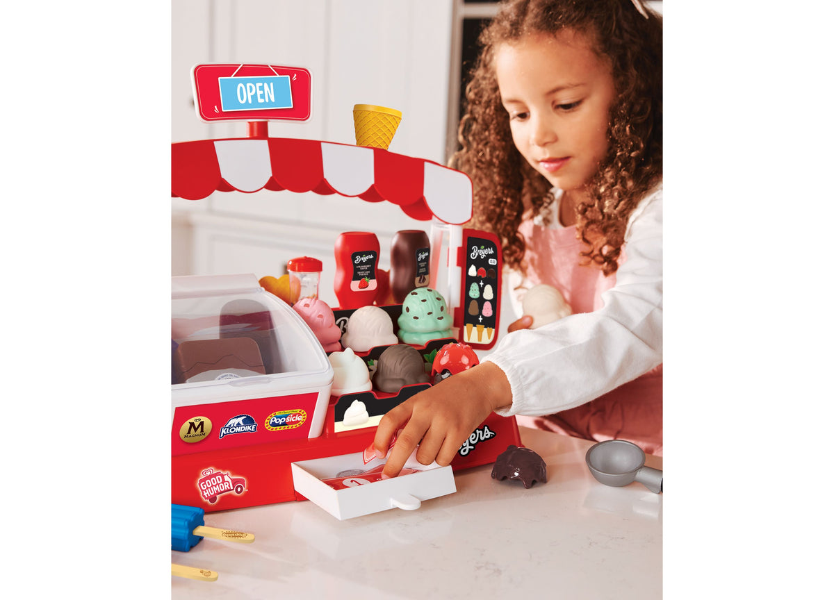 Casdon Ice Cream Parlor playset with red and white striped awning, featuring freezer, scoop stand, cash drawer, and 3...