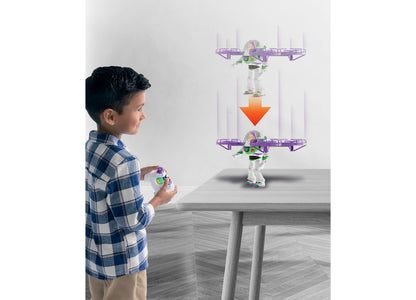 Boy with remote control operating Toy Story Buzz Lightyear RC flying figure with purple propellers against white wall