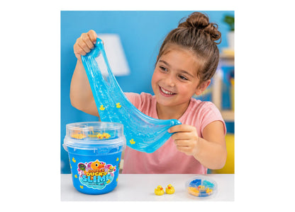 Child in pink shirt stretching blue Rubber Ducky Slime with yellow duck charms visible in bucket