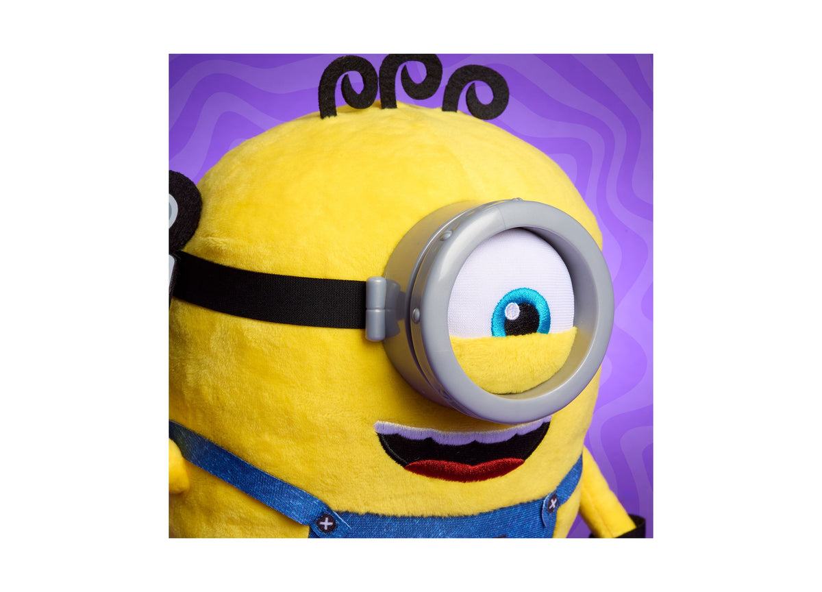Minions Interactive Babbling James 9" Plush toy with yellow body, black goggles, and blue overalls on purple background