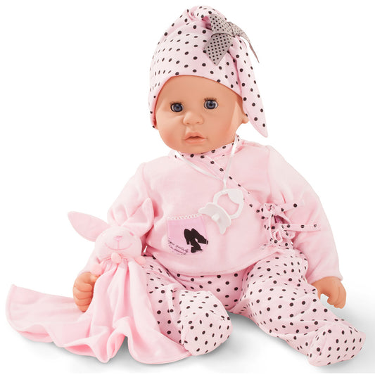 Baby doll with blue sleeping eyes wearing pink polka-dot bonnet, pink cardigan, and polka-dot pants, holding a pink plush toy