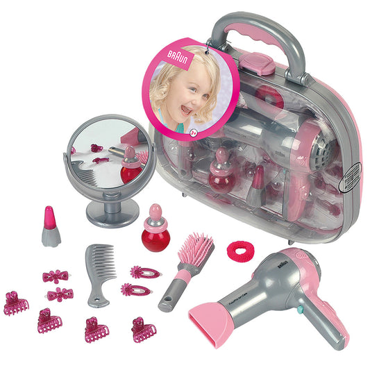 Braun toy beauty styling case with gray and pink carrying case, mirror, hair dryer, comb, brush, hair clips, hair accessories, and nail polish bottles on plain