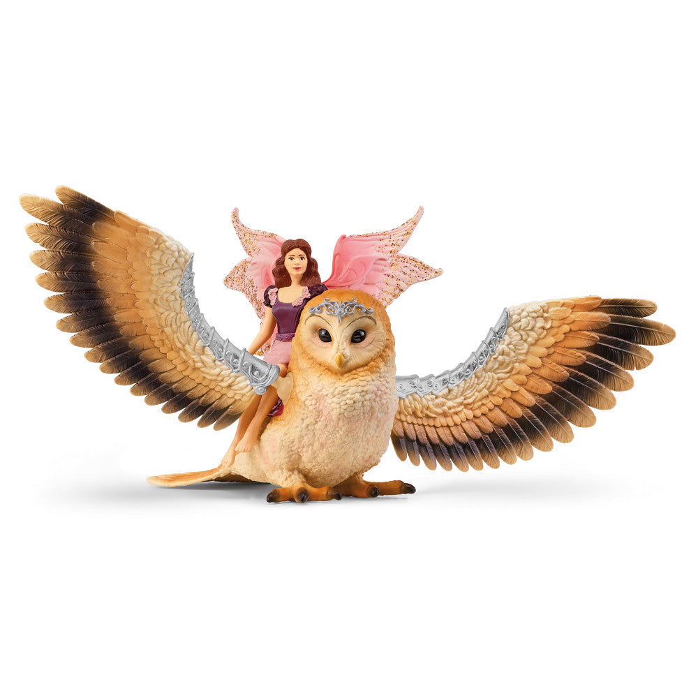 Schleich Bayala fairy figurine with brown hair in purple dress and pink sparkly wings riding on large cream and brown owl with detailed feathered wings