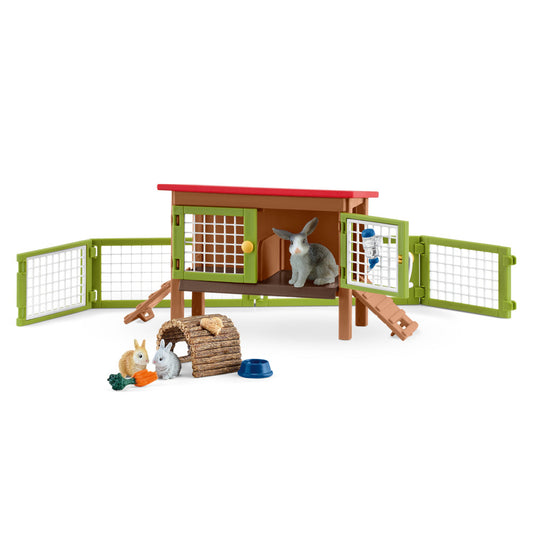 Rabbit hutch playset with green fencing, red roof, brown wooden structure, and included rabbit figurines, hay, vegetables, and food bowl