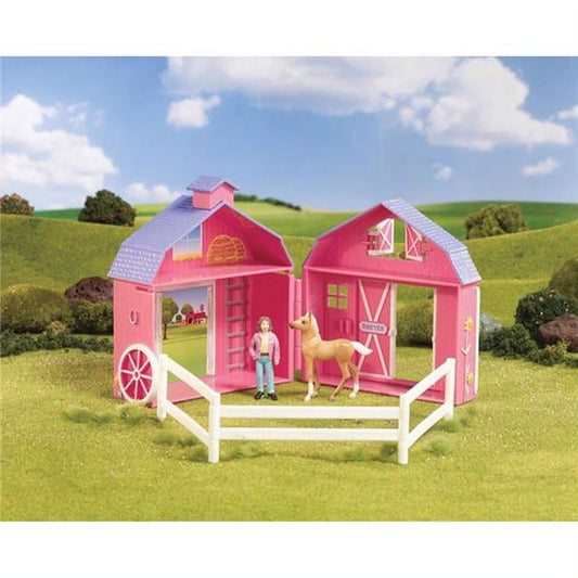 Pink barn playset with white fencing, featuring doll figure, tan horse, and detailed farm accessories on green landscape backdrop