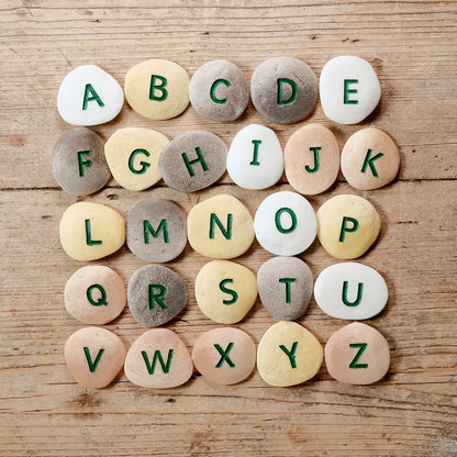 Uppercase Alphabet Pebbles Tactile Learning Set with 26 colorful stone letters on wooden surface
