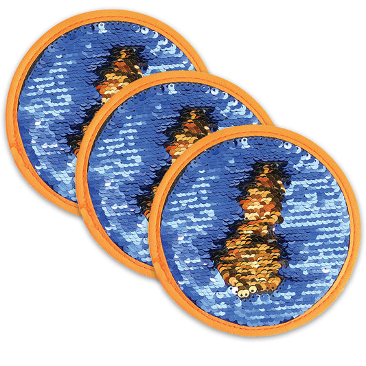 Three circular sensory discs with orange ribbed trim, featuring blue sequins that reveal black and gold sequins when swiped, arranged in overlapping rows