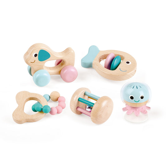 Five wooden sensory toys with natural finishes and pastel blue, pink, and teal accents including an elephant teether, fish rattle, heart-shaped teether, cylinde