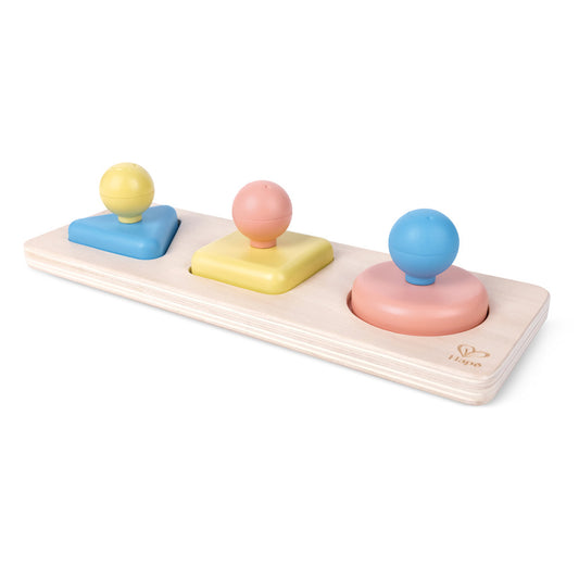 Wooden puzzle board with three colored pegs holding matching spheres and shaped bases in yellow, pink, and blue