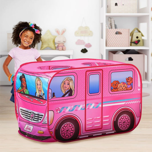 Pink Barbie camper play tent with illustrated windows showing Barbie characters and puppies, modeled by a child in a bedroom setting