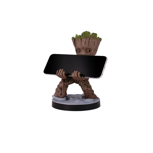 Groot figure with moss-covered head holding a black smartphone, standing on gray base with black rim