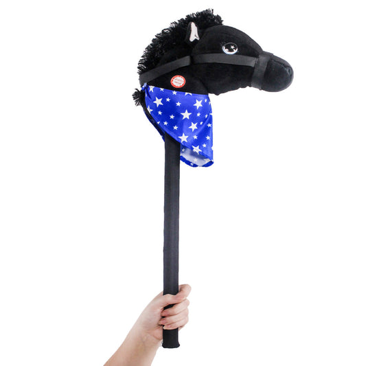 Black plush stick horse with furry mane, star-marked eye, and blue bandana with white stars, held in a child's hand on plain background