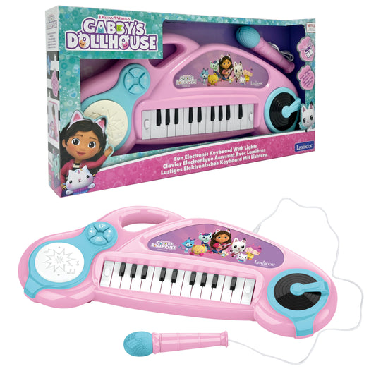 Gabby's Dollhouse pink electronic keyboard with turquoise accents, piano keys, light-up drum pad, DJ turntable, and pink microphone with cord; shown in packagin