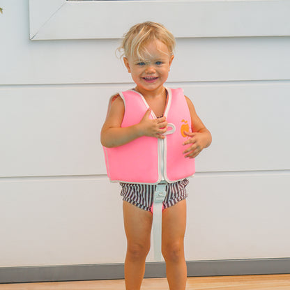 Sunnylife Poppy Peach Float Vest in neon pink with white trim, worn by toddler