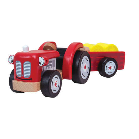 Red wooden tractor with trailer carrying yellow hay bales, black wheels with white-rimmed hubs, natural wood accents