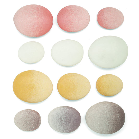 Twelve smooth, polished stones in pink, white, yellow, and gray arranged in four rows, decreasing in size from left to right