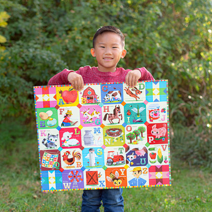 Child holding colorful 36 piece My Farm Alphabet puzzle with letters and farm animals on green background
