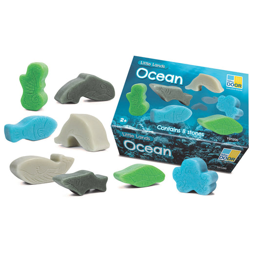 Little Lands Ocean set with 8 textured stone figures including whales, fish, sea turtle, and coral in green, blue, gray, and cream colors, shown with packaging