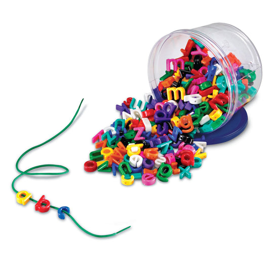 Colorful alphabet letters spilling from clear tipped bucket with green lacing string and threaded letter beads