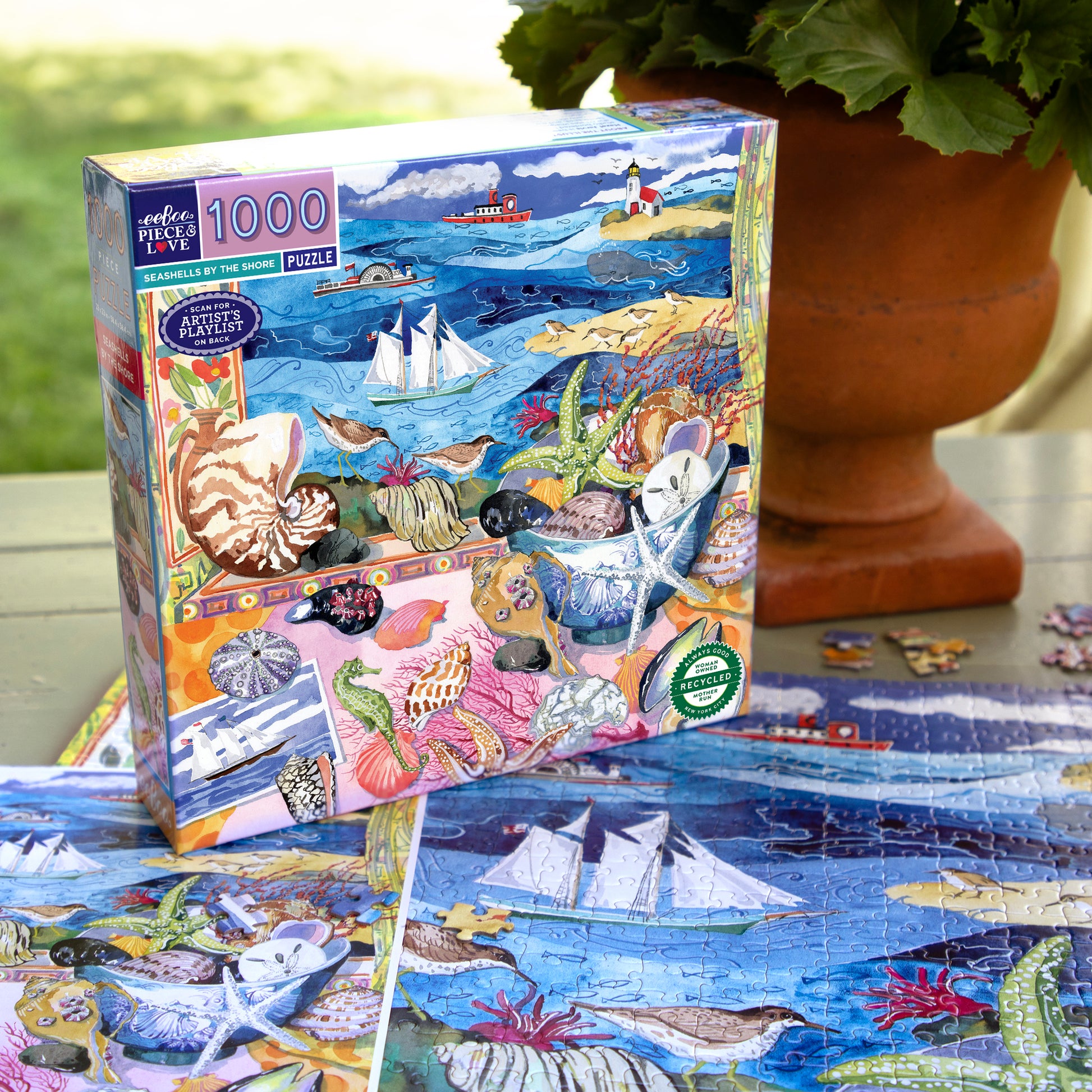 eeBoo Seashells by the Shore 1000 piece puzzle box and completed puzzle pieces showing colorful coastal ocean scene