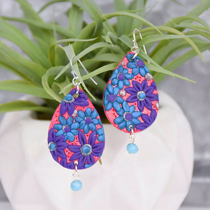 Colorful teardrop earrings with blue, purple, and coral floral patterns and dangling beads