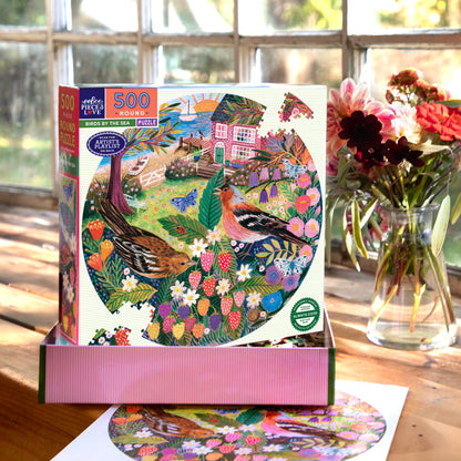 Piece&Love Birds By The Sea 500 piece round puzzle with colorful bird and floral design