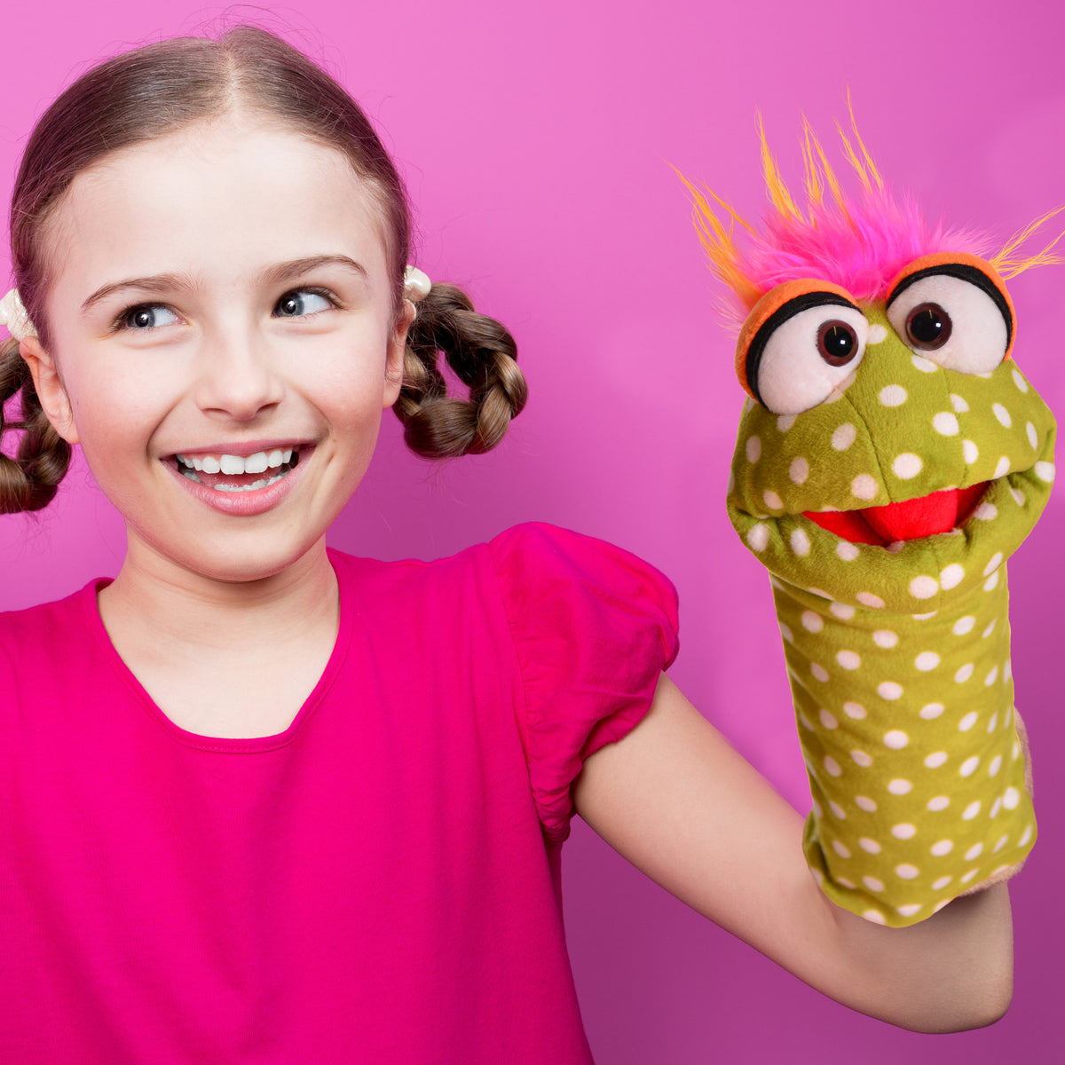 Living Puppets Shesha Sock hand puppet with green body, white spots, pink spiky hair, and movable mouth