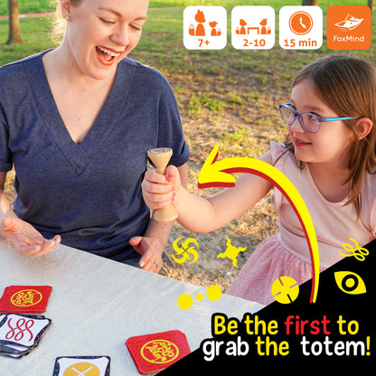 Jungle Speed Eco Edition card game with wooden totem, players matching cards and grabbing totem first