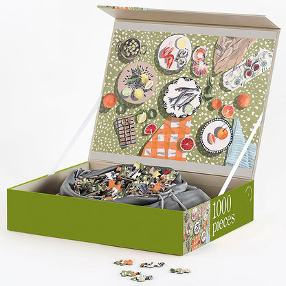 JOS 1000 Piece Puzzle - Table By The Sea with green box, picnic scene illustration, and puzzle pieces