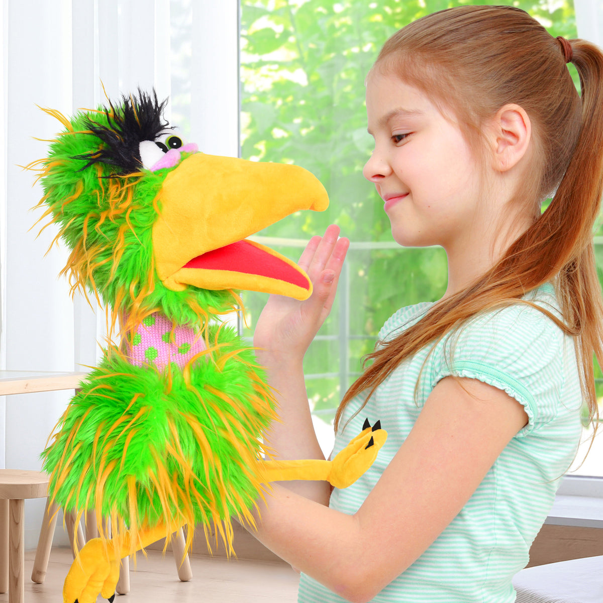 Living Puppets: Pickle The Bird hand puppet with green and yellow feathers, yellow beak, held by smiling child