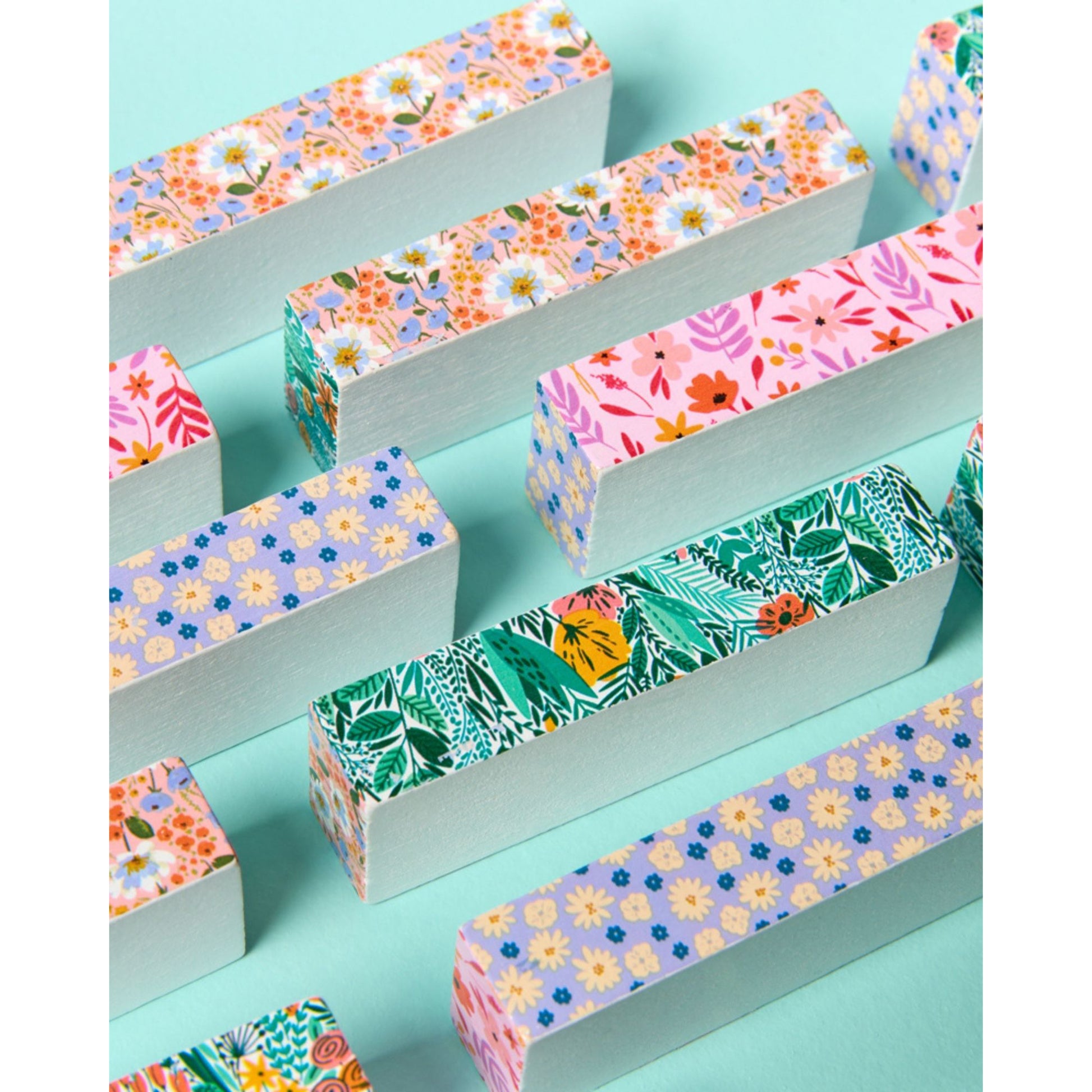JOS Tumbling Tower with colorful floral patterned wooden blocks on turquoise background