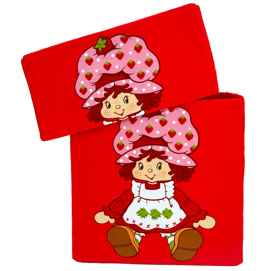 Strawberry Shortcake character with pink strawberry-patterned hat and red dress on red fabric storage bin