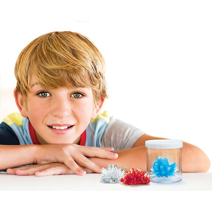 4M KidzLabs Crystal Science Kit with boy displaying grown red, white, and blue crystals
