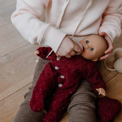 Jubilee Muffin Baby 13 inch soft doll in burgundy and gray outfit held by child